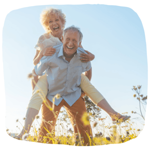 Older couple smiling at the camera outside