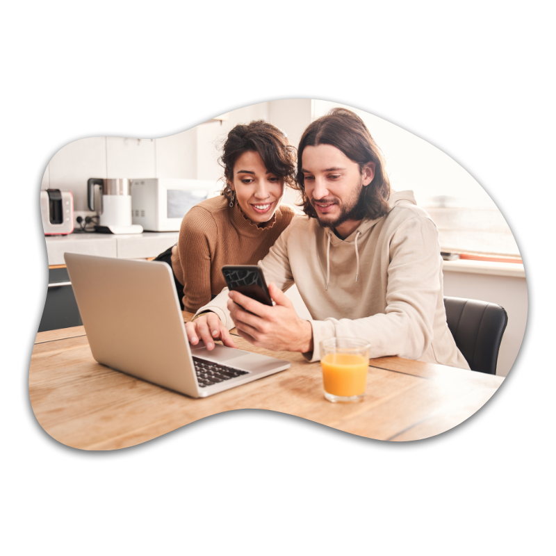 Young couple shopping online in their kitchen with a glass of orange juice