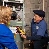 Shipley Energy HVAC Tech showing a homeowner her new furnace